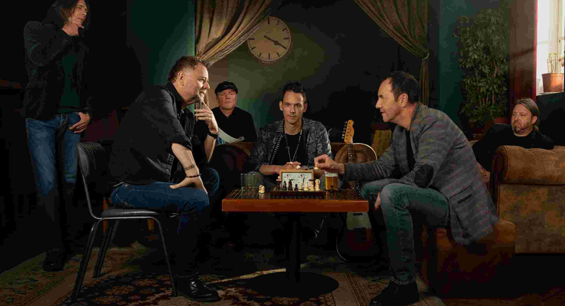 Klubska soba z moskimi za mizo.