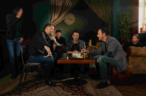 Klubska soba z moskimi za mizo.