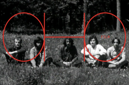 Stara crno-bela fotografija petih moskih, ki sedijo v vrsti na travniku, za njimi pa so drevesa.