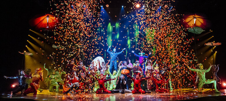 A circus on stage with confetti in the air.