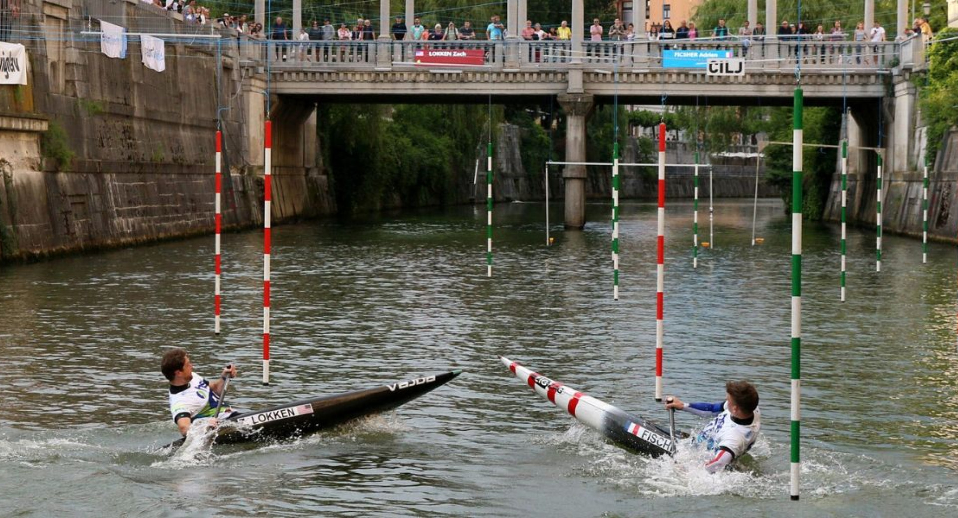 Two kayakers paddling through obstacles along the river.