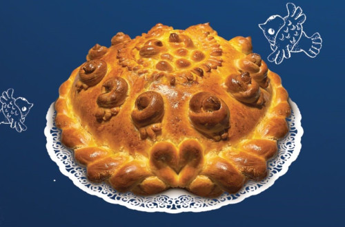 Bozicni kruh na belem prticu, ki je polozen na temno modrem prtu.