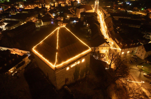 S praznicnimi luckami okrasena streha hise ter mestne ulice.