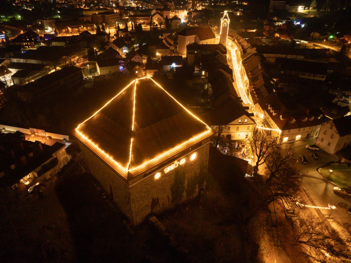 S praznicnimi luckami okrasena streha hise ter mestne ulice.