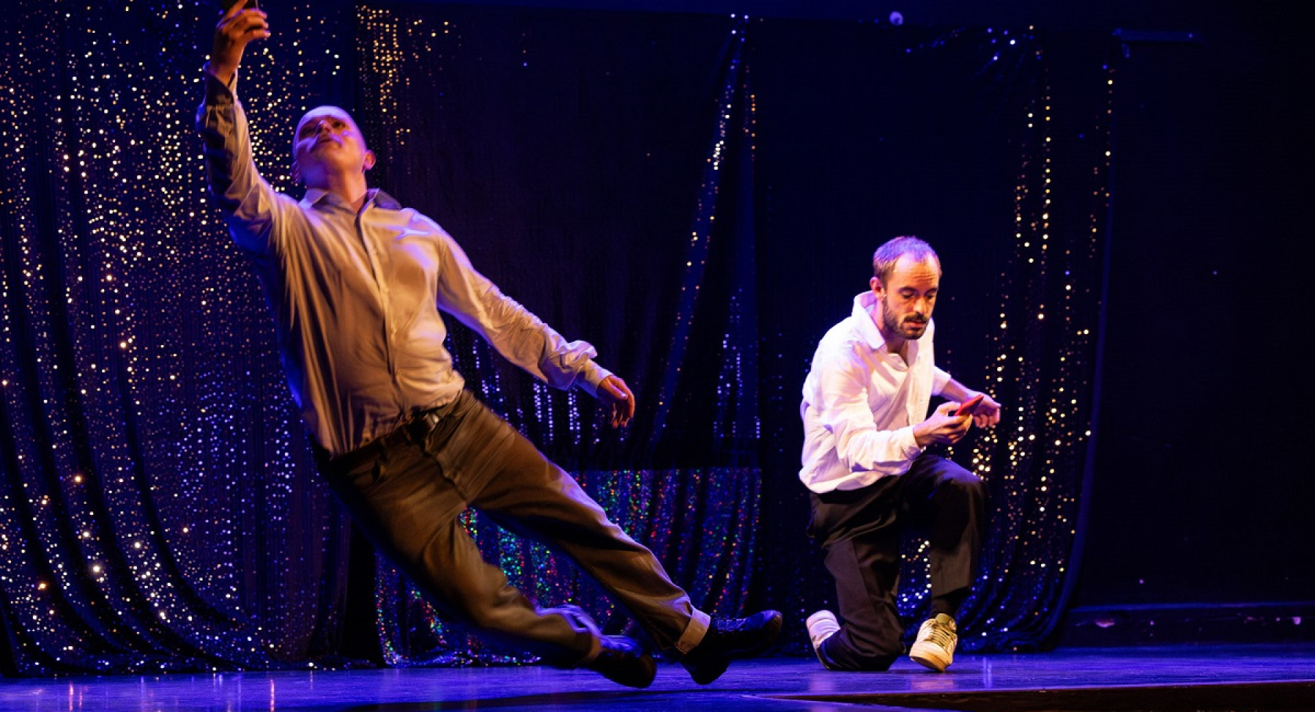 Two men on stage during a dance performance. 