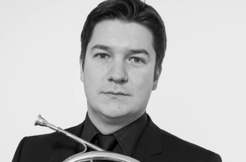 Moski v roki drzi francoski rog.