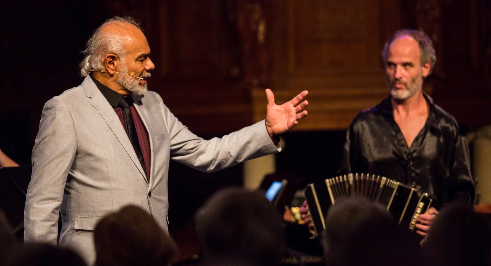 Moski poje, za njim moski igra harmoniko.