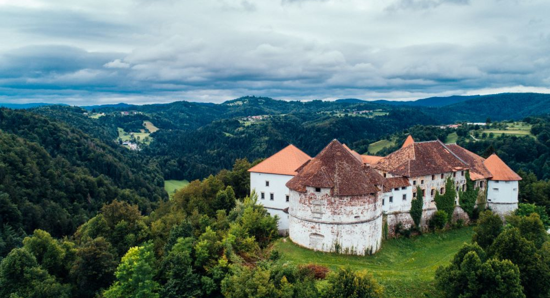 Velik bel grad sredi gozda v barocnem slogu.