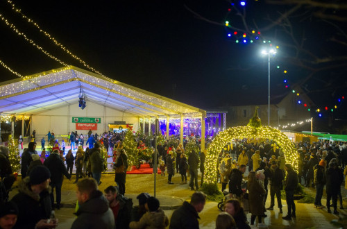 Praznicna noc na prostem, kjer se ljudje druzijo ob praznicni osvetlitvi.