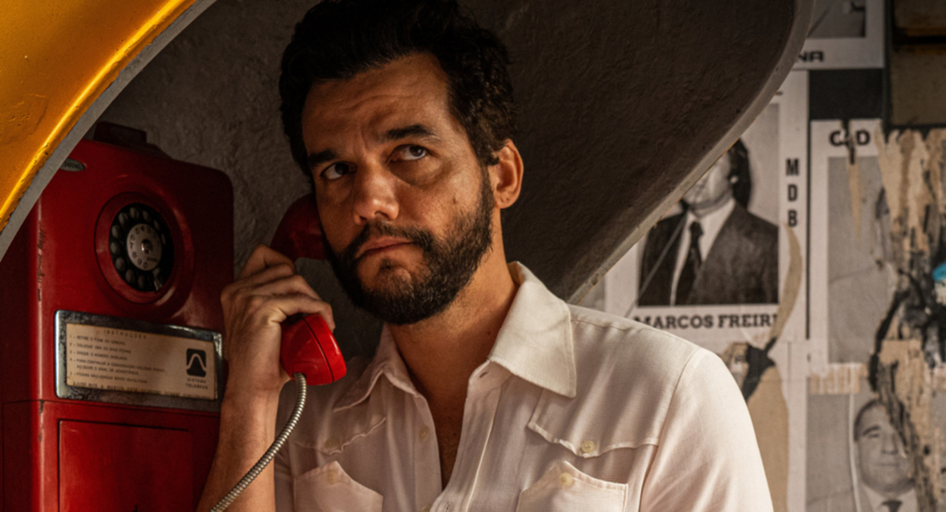 Moski v beli srajci se pogovarja po stacionarnem telefonu.