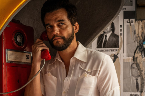 Moski v beli srajci se pogovarja po stacionarnem telefonu.