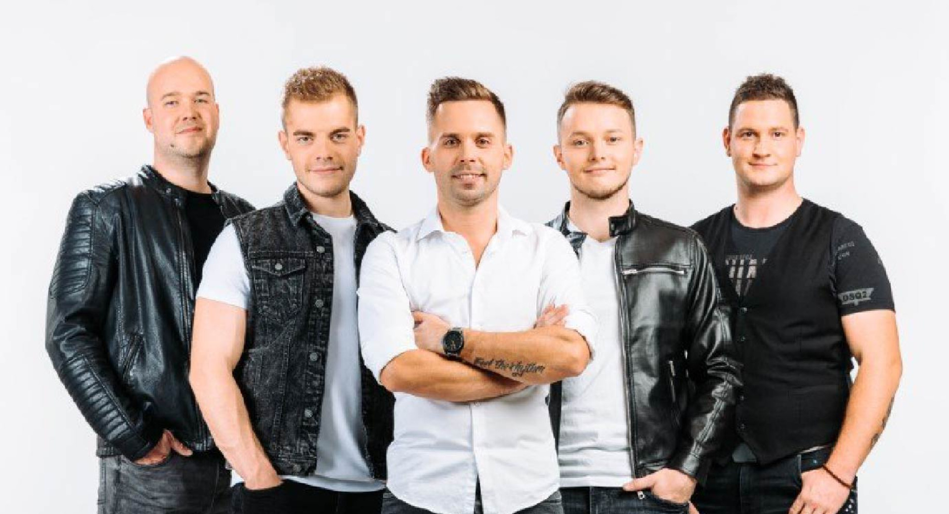 Pet moskih stoji in pozira pred kamero v belo-crnih oblacilih.