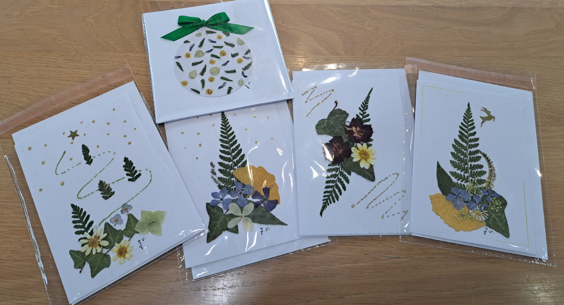 Pet rocno izdelanih voscilnic iz naravnih materialov na leseni mizi.