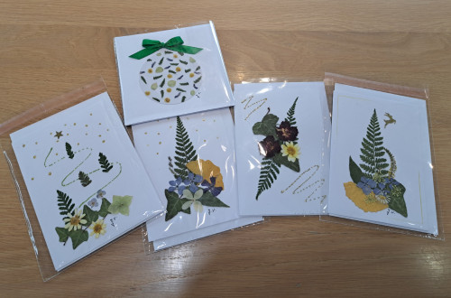 Pet rocno izdelanih voscilnic iz naravnih materialov na leseni mizi.