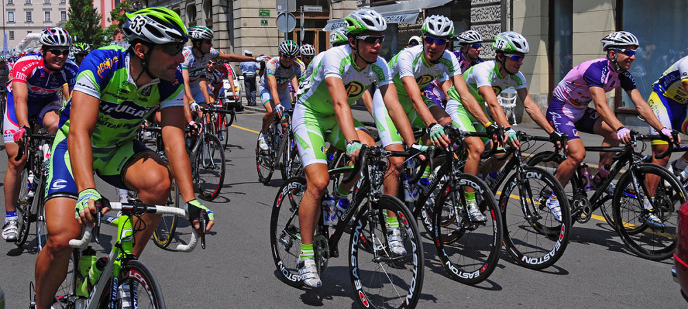 Cyclists in jerseys are riding through the city.