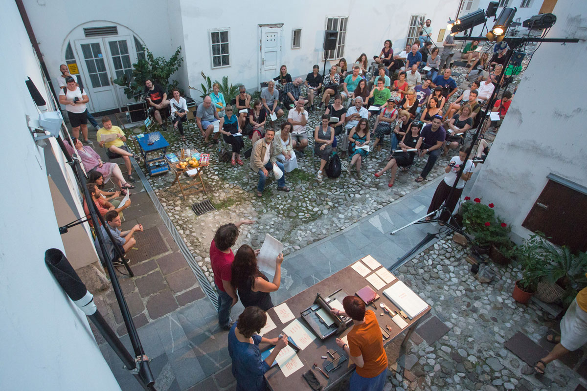A group of people gathered on a street between houses.
