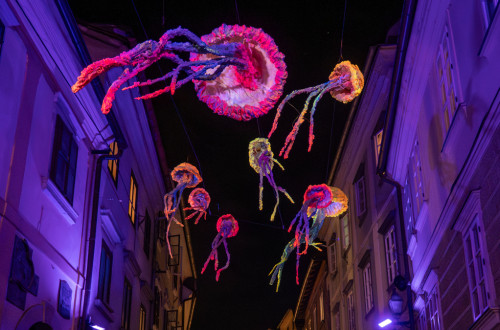 Umetniske instalacije v obliki meduz nad mestom ponoci.