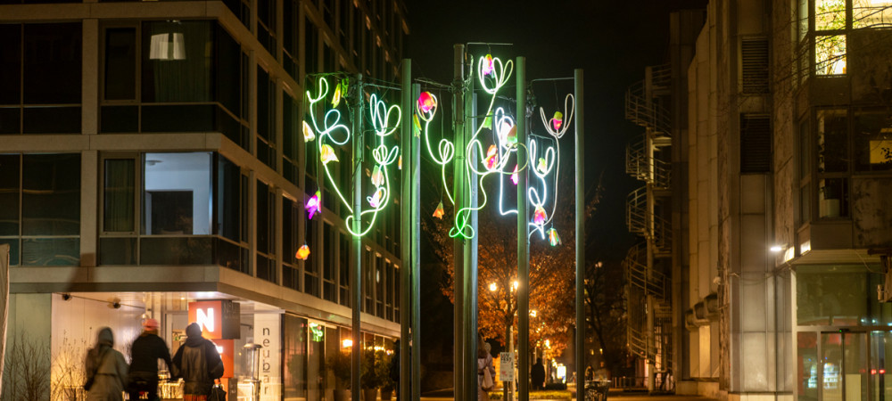 Street lamps decorated with light installations of roses.