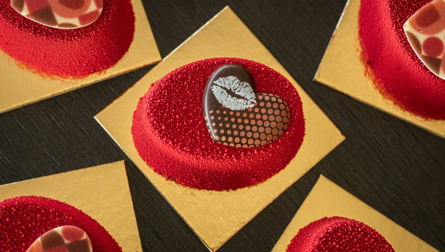 Rdeca sladica z rjavim srckom na zlati podlagi.