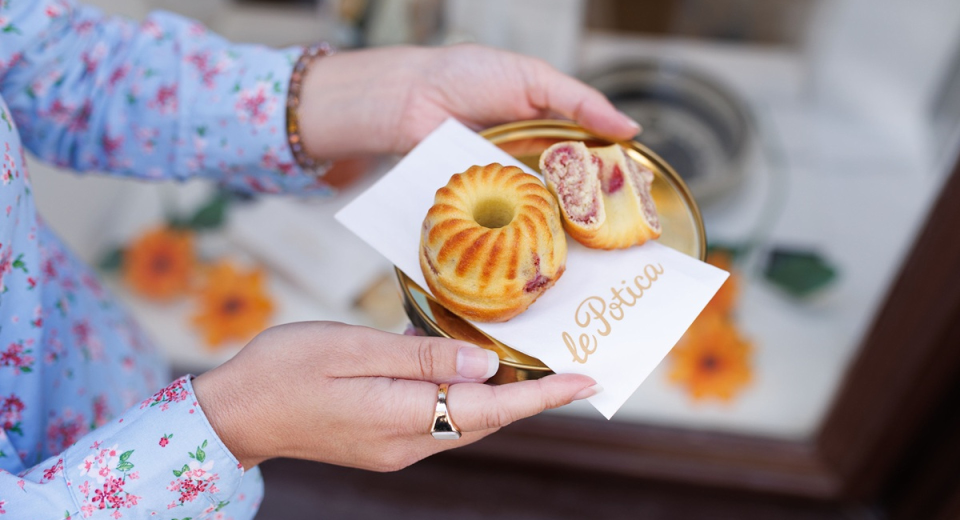 Majhna malinova poticka in na pol prerezana poticka na prticku v zenskih rokah.