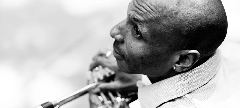 Crnobela fotografija moskega s trobento.