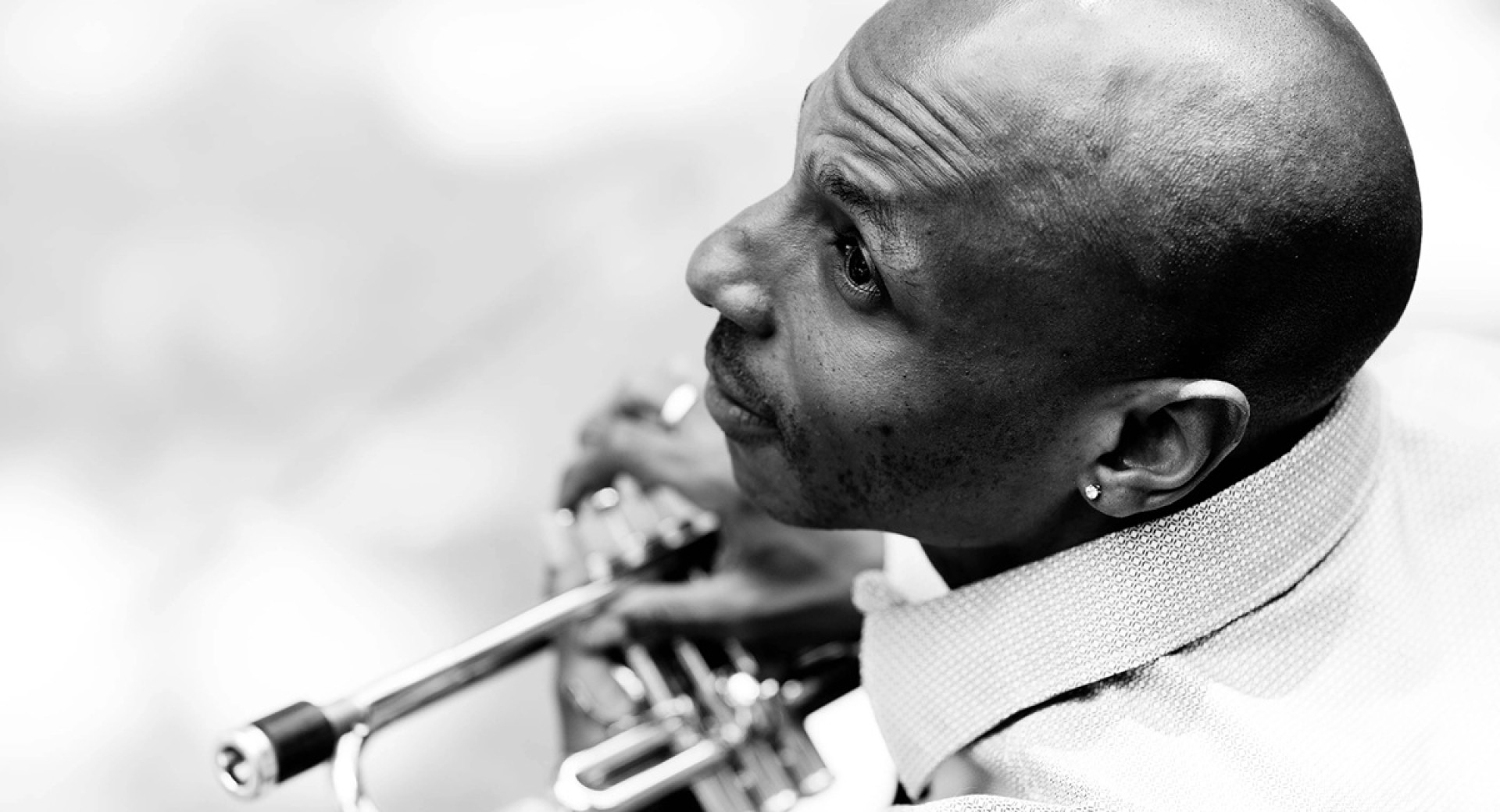 Crnobela fotografija moskega s trobento.