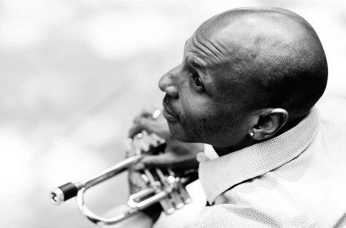 Crnobela fotografija moskega s trobento.