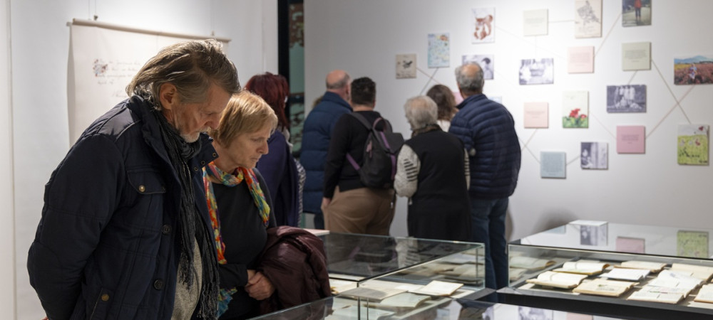 Skupina obiskovalcev si ogleduje razstavo.