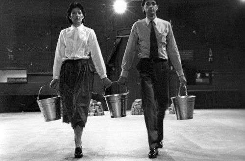 Crnobela fotografija moskega in zenske s srebrnimi vedri v rokah.