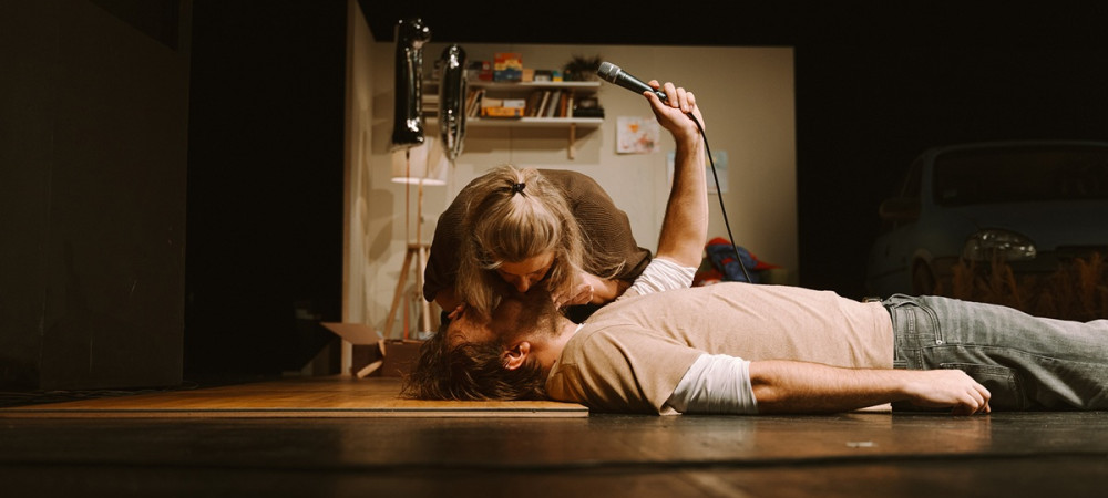 Moski lezi na tleh, zenska pa mu daje umetno dihanje.