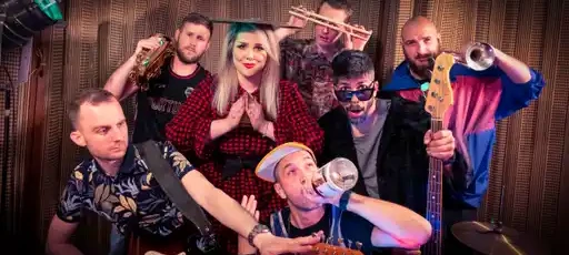 7-clanski bend pred leseno steno.