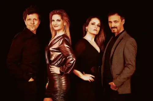 Dve zenski in dva moska pred crnim ozadjem.