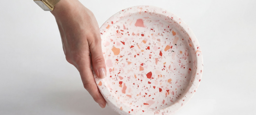 Roka z zlato uro drži krožnik narejen iz teraca.