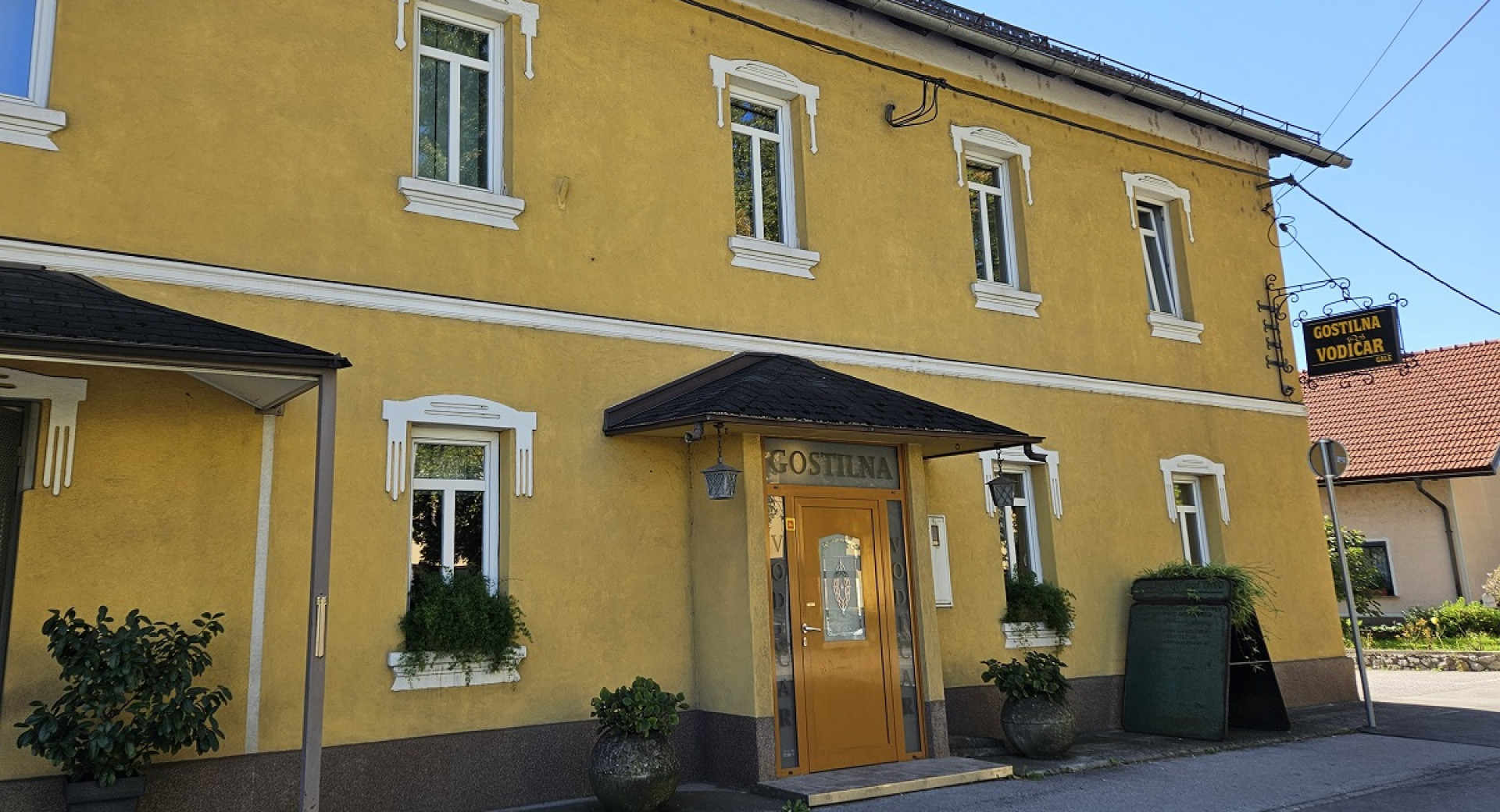 Velika rumena hisa z napisom Gostilna Vodičar. 