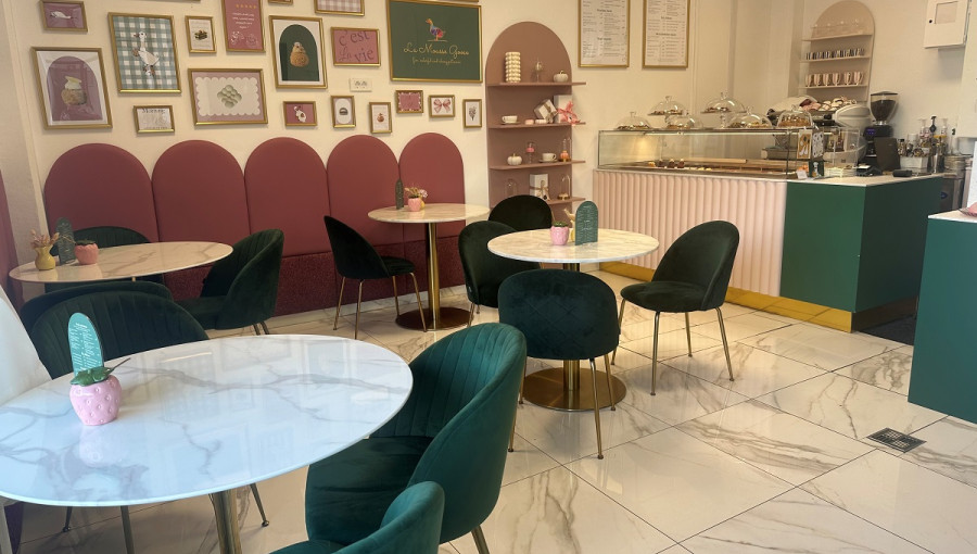 The interior of a cafe with green and red chairs.