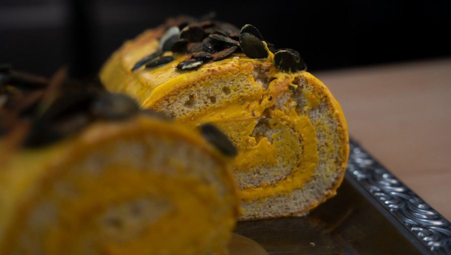 Orange roulade with pumpkin seeds cut in half.