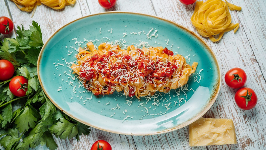 Pasta with tomato sauce on a turqoise platter.