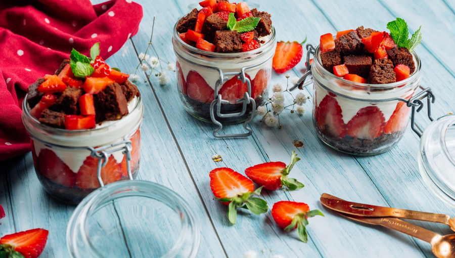 Strawberry, White Cream, and Chocolate Desserts in Glasses on the Table
