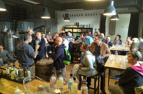 People are seated at bar tables, chatting over drinks.