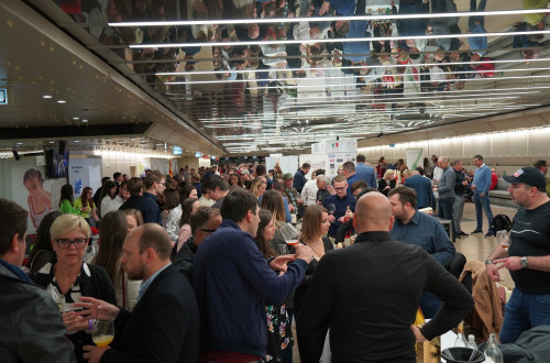 A crowd of people in a room with a low ceiling.