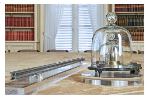 A brown table with a weight and a long metal rod – measuring instruments.