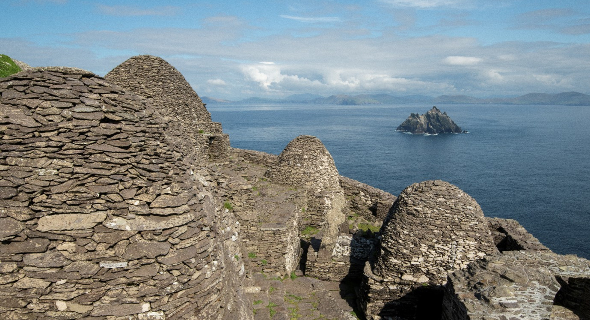 Samostansko kamnito naselje na visoki skali v oceanu. 