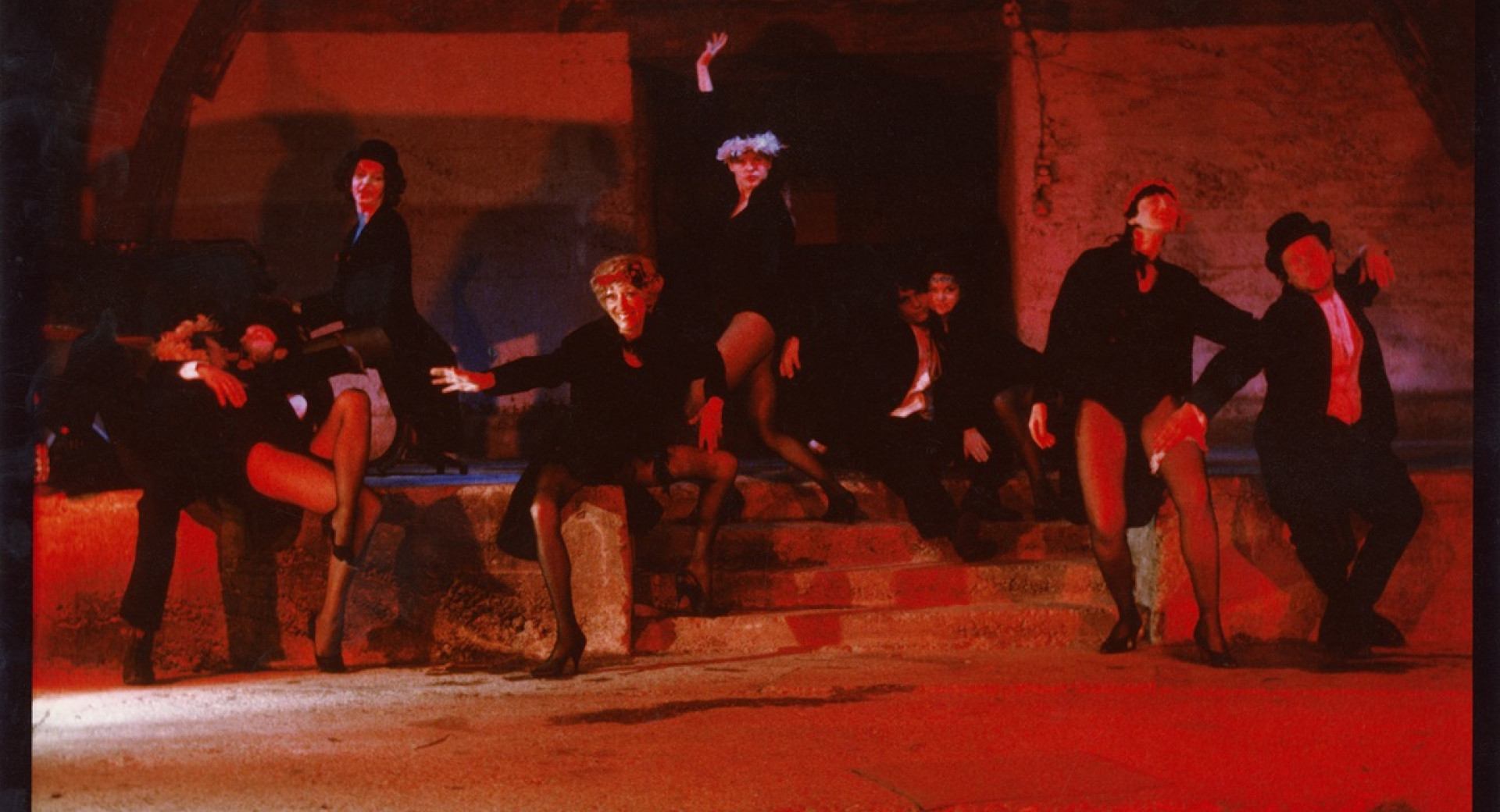 Starinska rdeckasta fotografija igralcev v temnih oblacilih. 