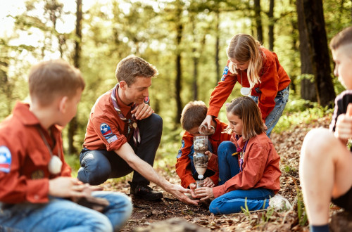 Skavti v gozdu ustvarjajo ter se ucijo o zemlji in kamnih.