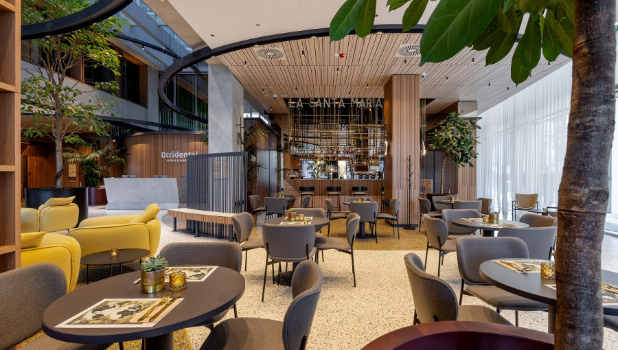 Notranjost moderne restavracije. Restavracija s sivimi in rumenimi stole.