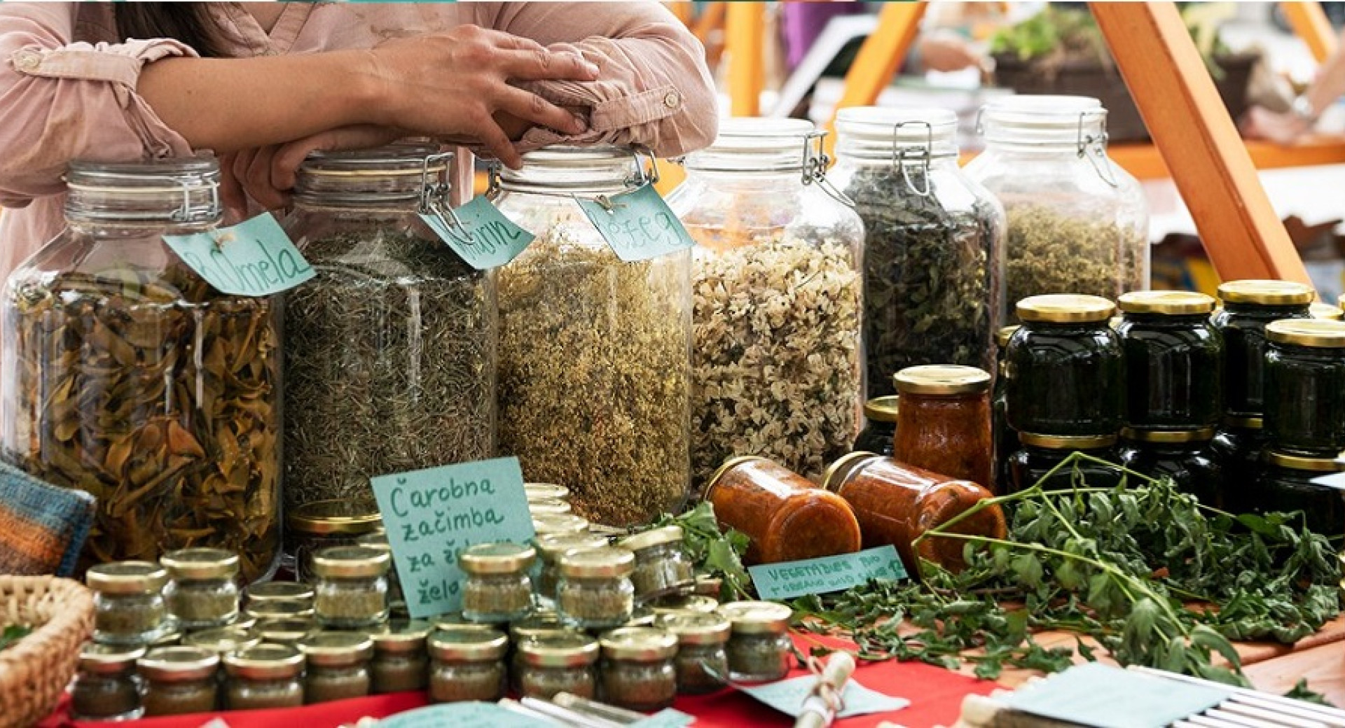 Herbs and herbal products in different packages on an outdoor stand.