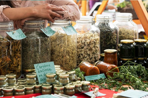 Herbs and herbal products in different packages on an outdoor stand.