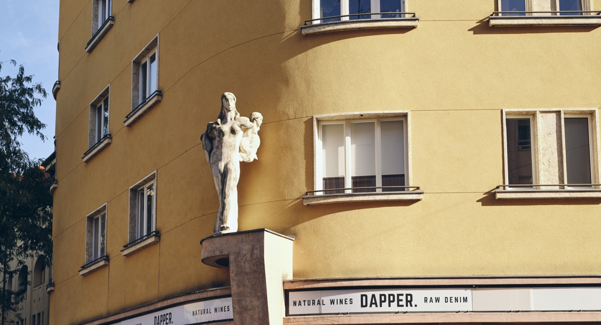 Pogled na rumeno vogalno stavbo z napisom Dapper.