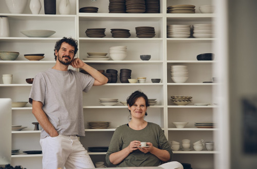 Moski in zenska pred belo omaro s keramiko.