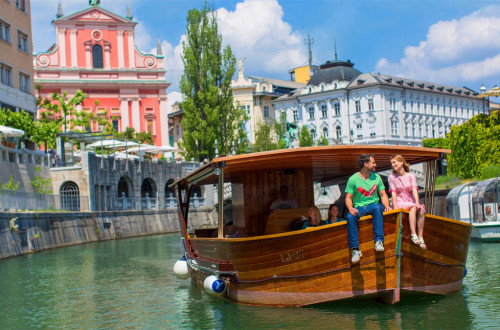 Ladjica na Ljubljanici. V ozadju Frančiškanska cerkev.